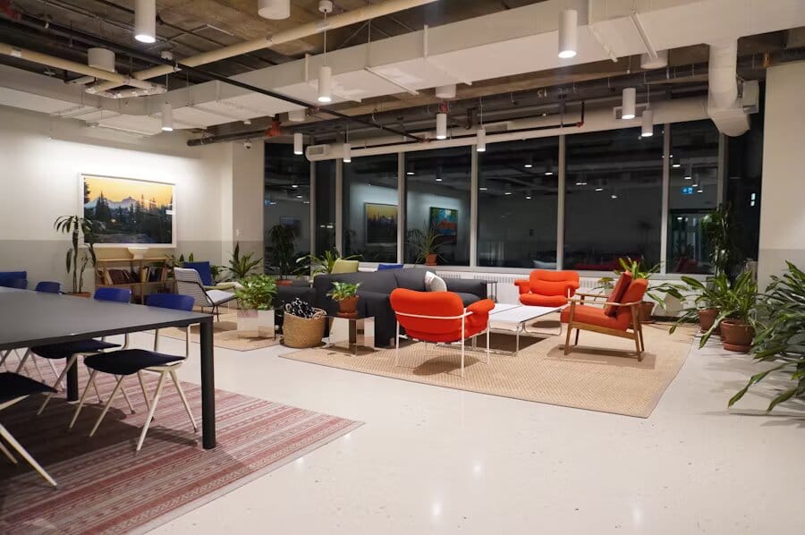 Coin salon dans un espace de travail partagé avec fauteuils orange, plantes en pot et ambiance chaleureuse